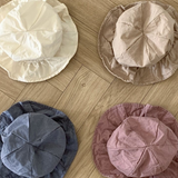 Vier zerknitterte Crunch Bucket Hats liegen in einem 2x2-Raster auf einem Holzboden. Die Hüte in einer natürlichen Farbpalette aus Beige, Hellbraun, Blau und Rosa haben jeweils eine zerknitterte Textur, die ihnen ein lässiges Aussehen verleiht. Perfekt für die Kleinen von Bebe Holic.