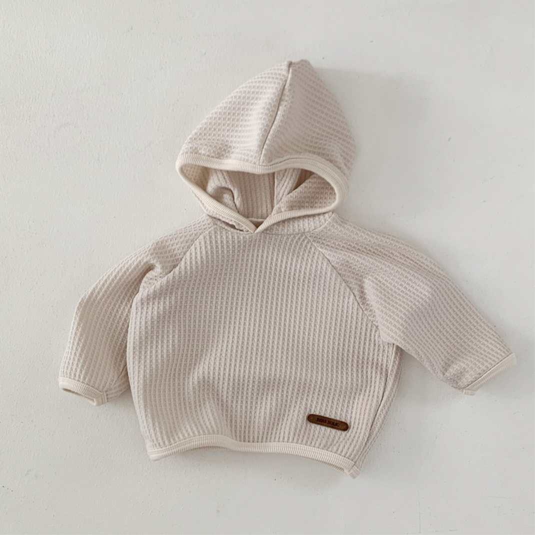 Monica Hoodie in soft beige waffle texture, perfect for babies and toddlers, combines style and functionality.